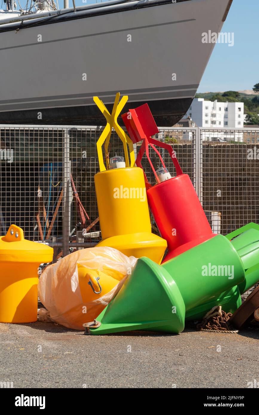 Penzance Harbour, Cornovaglia, Inghilterra, Regno Unito. 2022. Selezione colorfull di boe in plastica per la navigazione e la navigazione sul muro del porto. Penzan Foto Stock