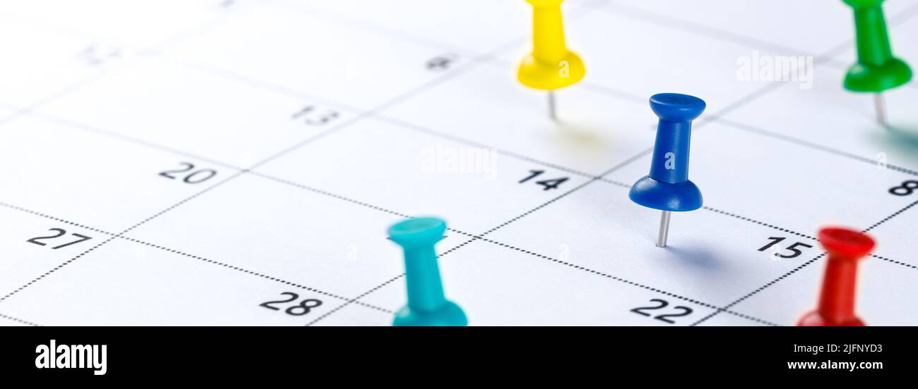 Pin a pressione colorati sul calendario che mostrano la pianificazione occupato - concetto di pianificazione aziendale Foto Stock