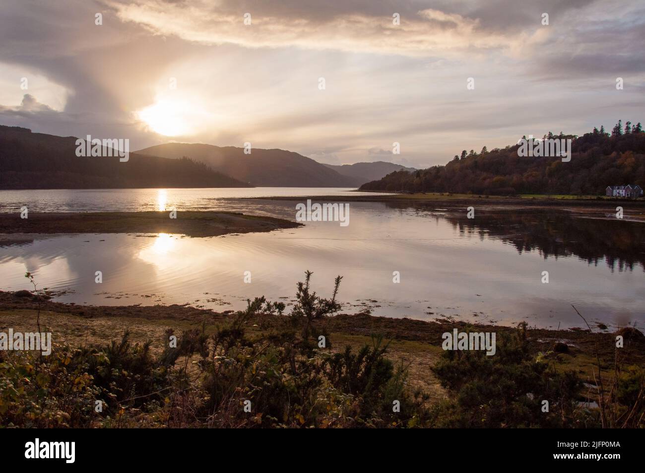 Il sole inizia a tramontare in Loch Sunart dietro le spettacolari nuvole Foto Stock