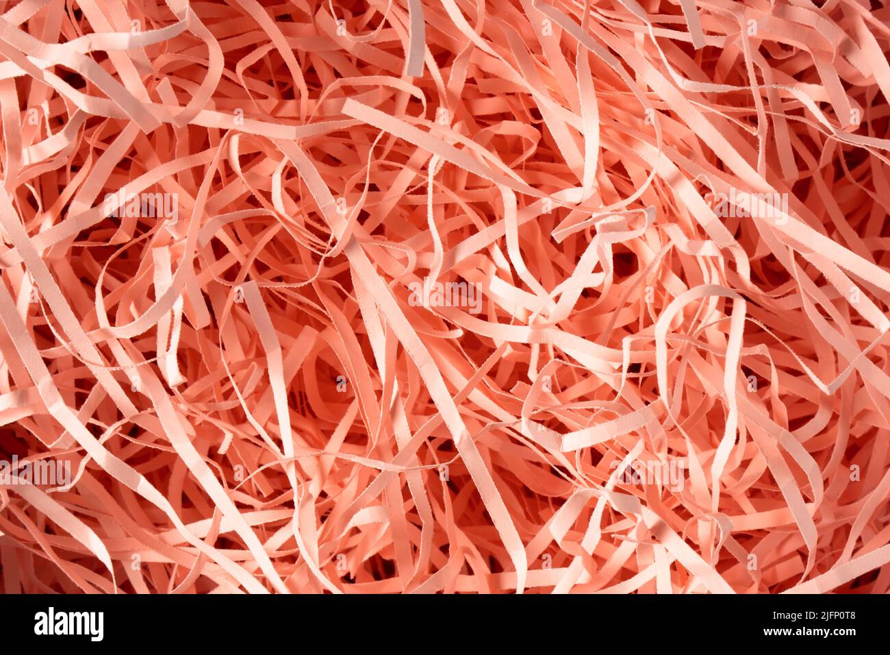 Texture Spaghetti rosa grattugiato carta da imballaggio. Carta utilizzata per proteggere gli oggetti fragili durante il trasporto, il riempimento delle confezioni regalo e la confezione regalo. Foto Stock
