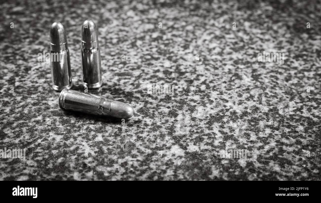 Tre cartucce Tokarev (TT) (7,62 x 25mm) su sfondo grigio di granito, foto monocromatica Foto Stock