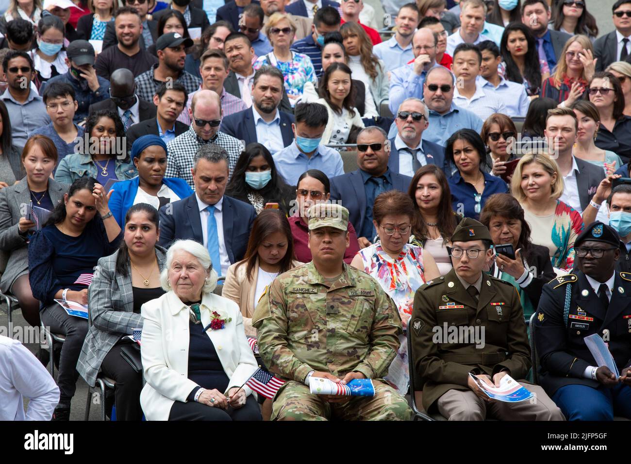 Seattle, Washington, Stati Uniti. 4th luglio 2022. I nuovi cittadini statunitensi ascoltano il governatore di Washington Jay Inslee durante una cerimonia di naturalizzazione al Fisher Pavilion. I servizi di cittadinanza e immigrazione degli Stati Uniti e il tribunale distrettuale degli Stati Uniti per il distretto occidentale di Washington hanno collaborato con il Seattle Center per ospitare la cerimonia annuale che ha accolto 300 candidati provenienti da 74 paesi come nuovi cittadini. Credit: Paul Christian Gordon/Alamy Live News Foto Stock