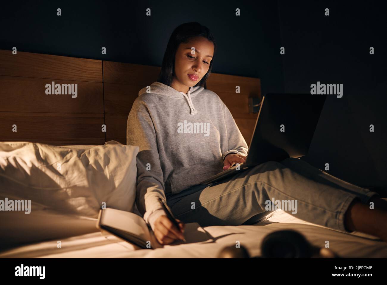 Preparazione dell'esame finale Scatto corto di una giovane donna attraente che studia a tarda notte nella sua camera da letto a casa. Foto Stock