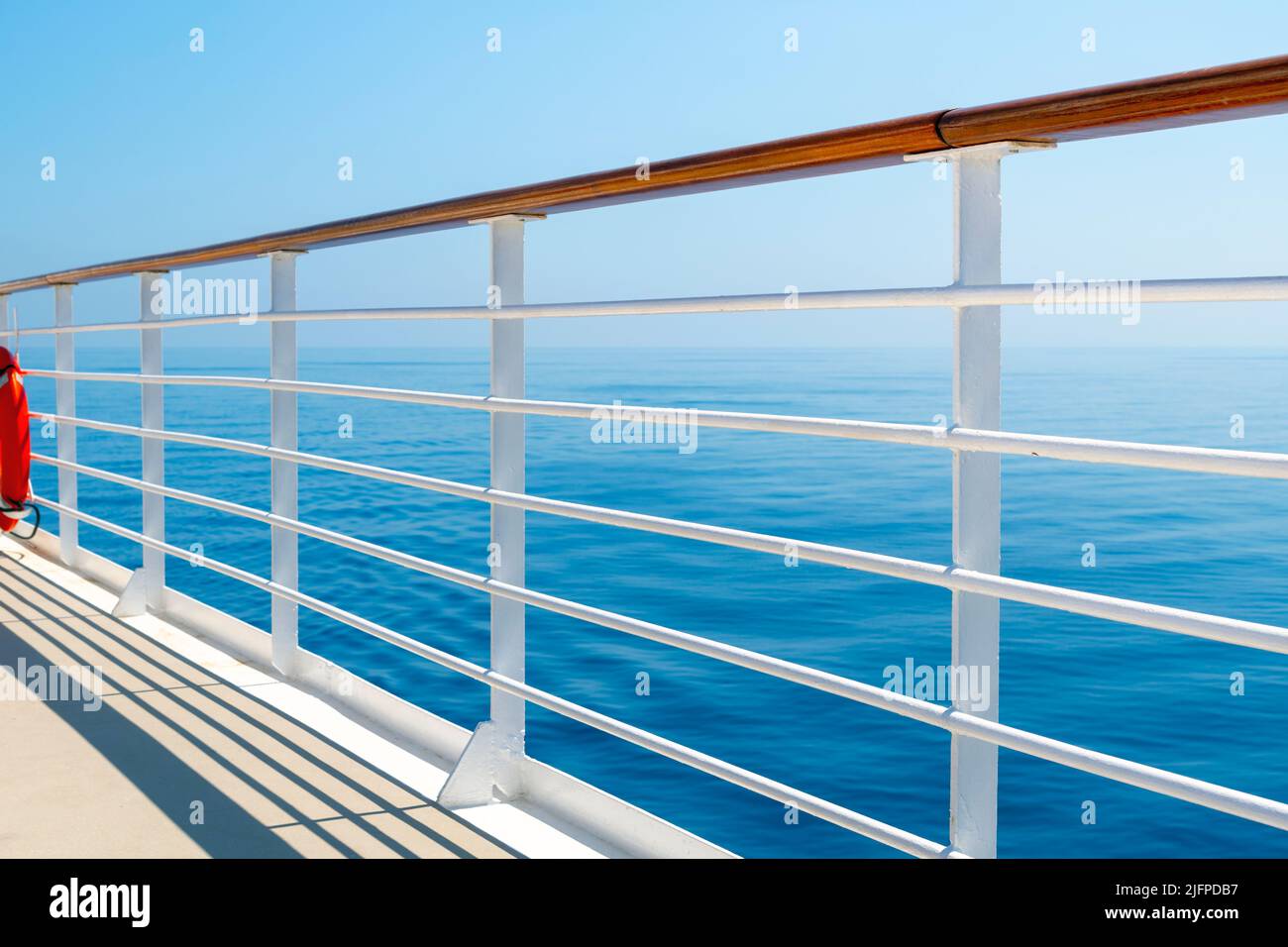 Vista dell'oceano blu e del cielo dal ponte sul lungomare superiore di una nave da crociera in mare. Foto Stock
