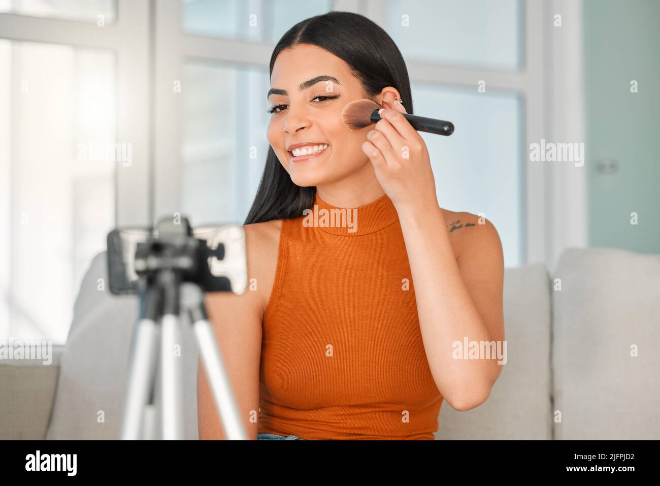 La bellezza è il nome del gioco. Scatto corto di un attraente giovane influencer di bellezza in streaming dal vivo dal suo salotto a casa. Foto Stock