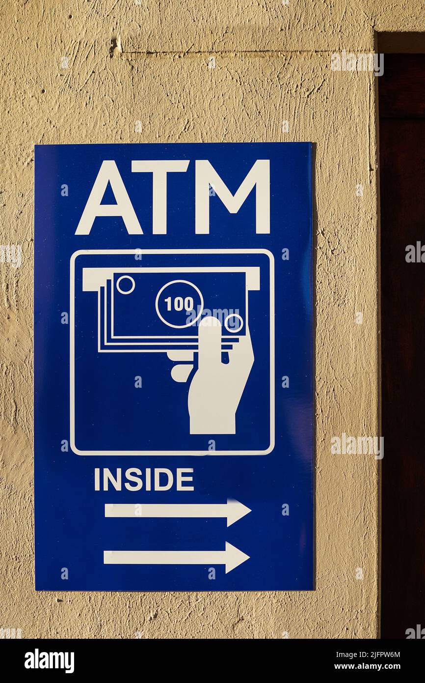 Cartellonistica o cartellonistica ATM montata su un muro che mostra la freccia direzionale e le icone Concept Financial and Banking Industry o Travel Foto Stock