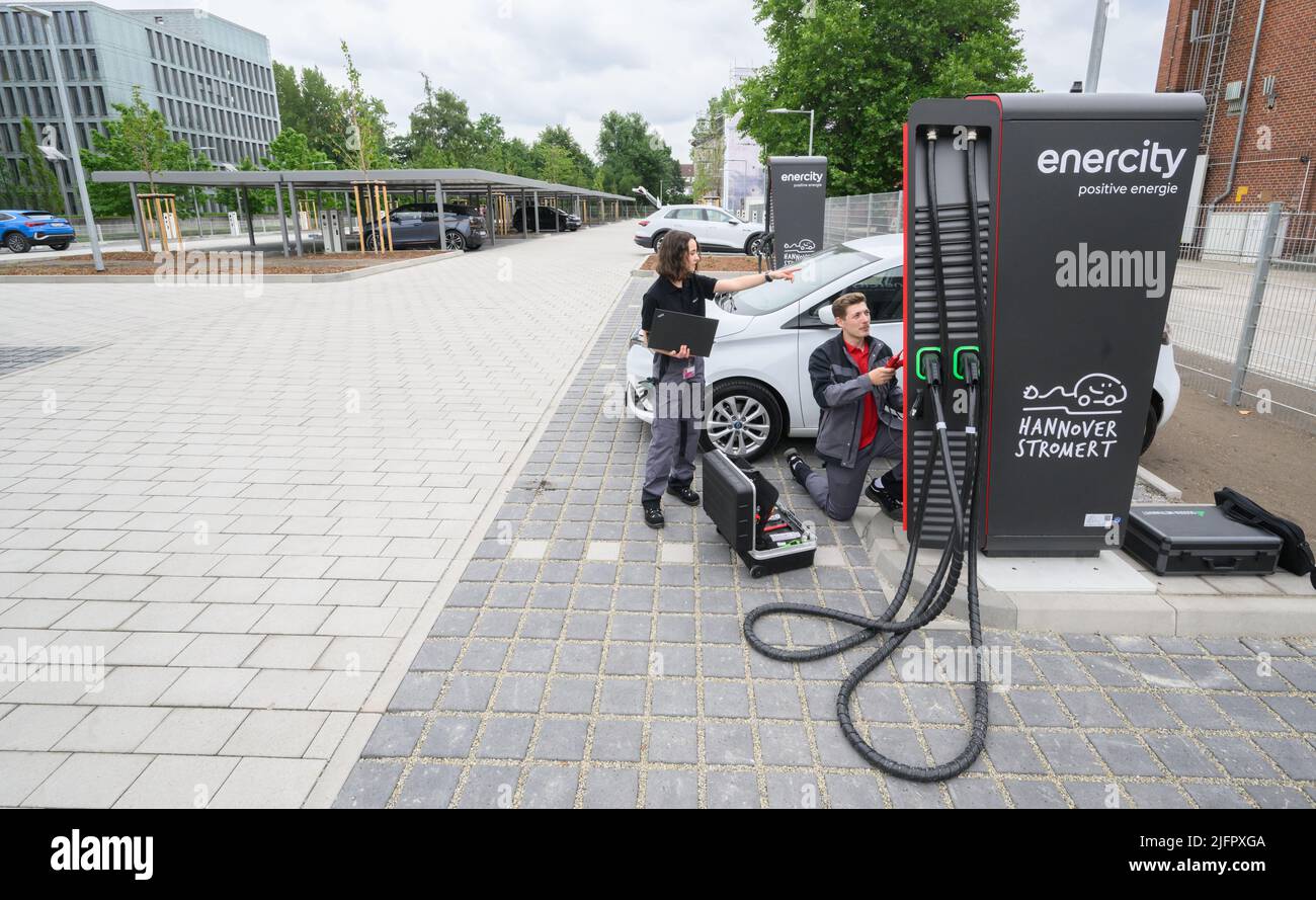 Hannover, Germania. 01st luglio 2022. I tecnici di Enercity si trovano a un punto di ricarica veloce in un nuovo parco di ricarica (posto scena per scattare foto). L'utility regionale Enercity sta aprendo un parco di ricarica per le auto elettriche nel distretto List di Hannover. I residenti hanno accesso a 84 punti di ricarica con una potenza di 22 kW e a sei punti di ricarica rapida con una potenza massima di 150 kW ciascuno. 60 punti di ricarica sono già stati affittati da 30 anni. Credit: Julian Stratenschulte/dpa/Alamy Live News Foto Stock