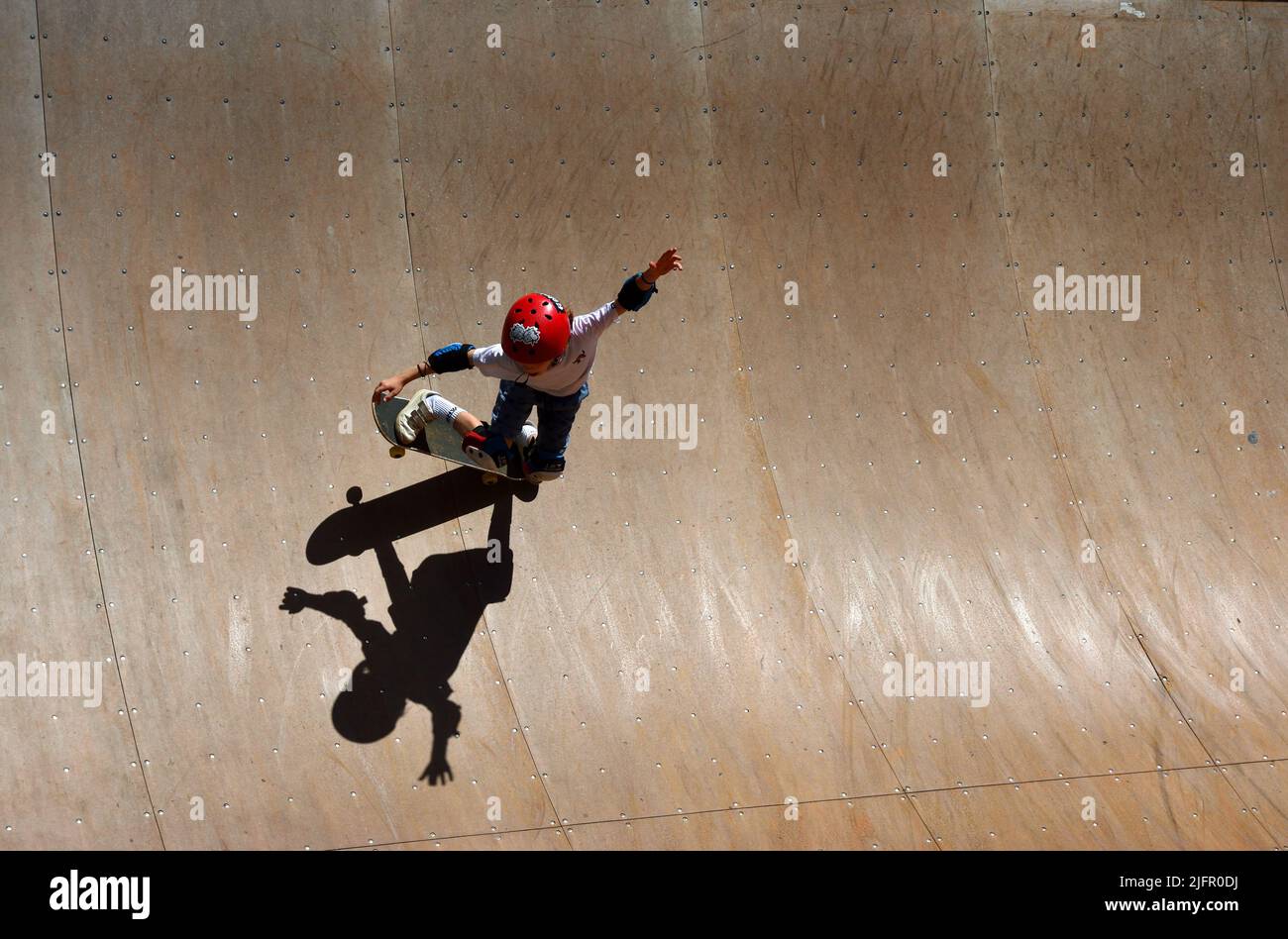 Skateboarder su rampa con forte ombra Foto Stock