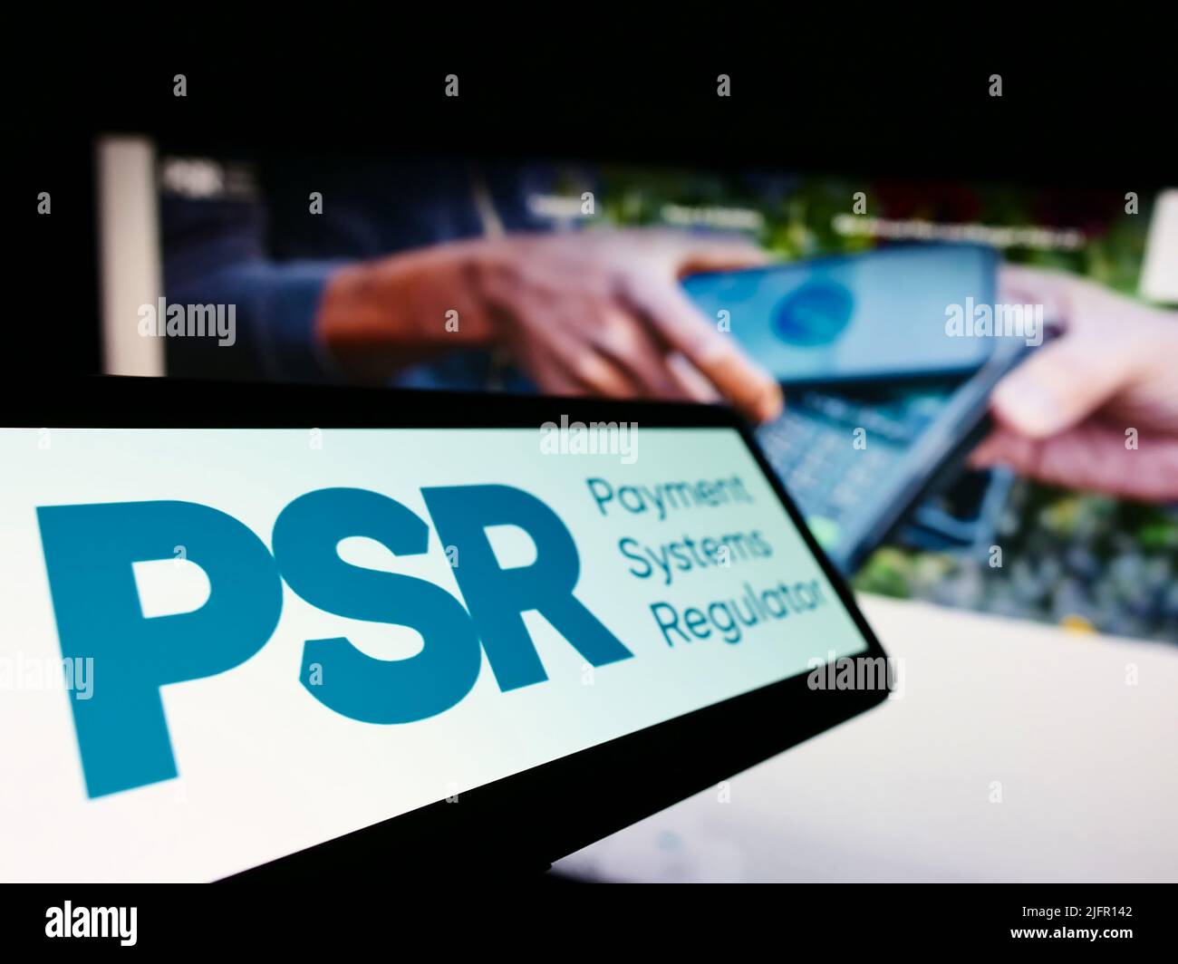Smartphone con logo di British Payment Systems Regulator (PSR) sullo schermo di fronte al sito Web aziendale. Messa a fuoco al centro-sinistra del display del telefono. Foto Stock