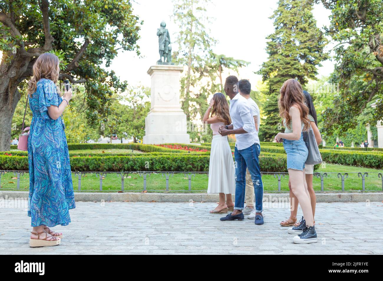 Profilo di un gruppo di amici multietnici che visitano una città utilizzando una guida turistica Foto Stock