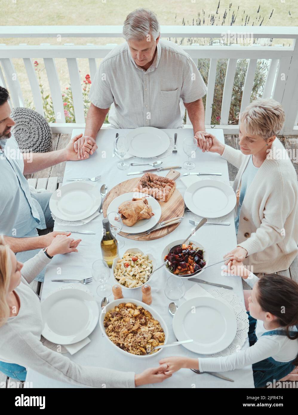 Benedici il cibo che ci è stato davanti. Shot di una bella famiglia che benedice il cibo con una preghiera al tavolo insieme a casa. Foto Stock