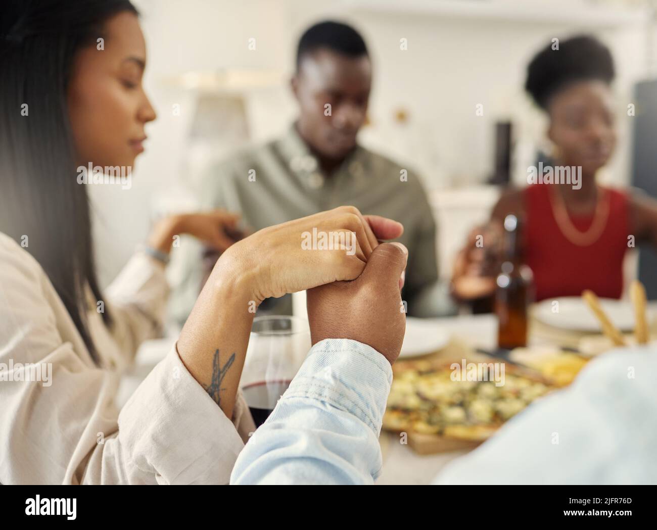 Sono stati grati per questo momento. Shot di un gruppo di amici che dice grazia prima di mangiare un pasto insieme. Foto Stock