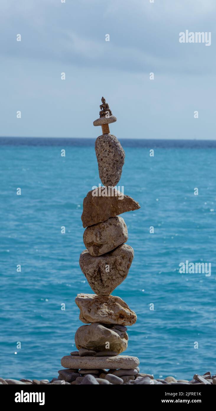 L'arte del riposo, del rilassamento e della meditazione e di mettere le pietre con cura in un equilibrio perfetto. Un alto mucchio di pietre poste in equilibrio e abov Foto Stock