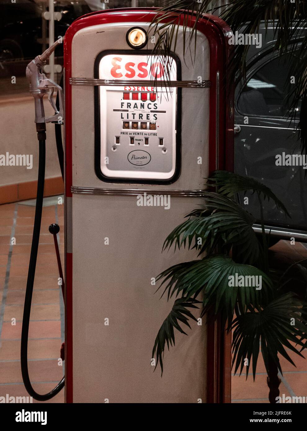 Monaco, aprile 2022. Una vecchia pompa di carburante d'epoca tra le foglie di una palma, un oggetto che fa parte della collezione auto del Principe di Monaco. Foto Stock