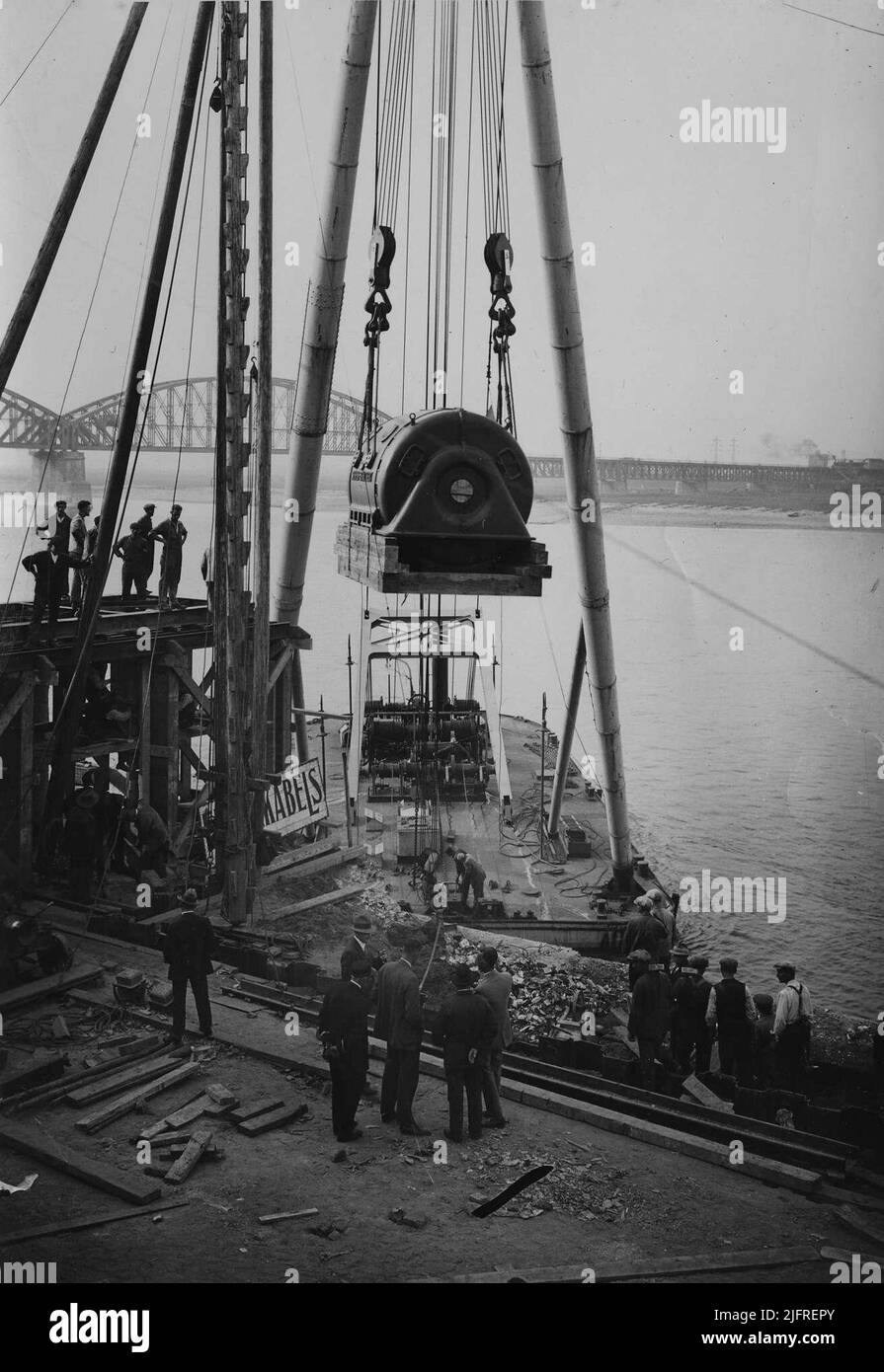 Scarico del trasporto navale con la parte Siemens-Schuckert per una delle turbine del locale macchine del nuovo 'Central Gelderland', costruito per conto della provincia e della provincia Geldersche Electriciteits Maatschappij (PGEM) su progetto dell'architetto Hendrik Fels Foto Stock