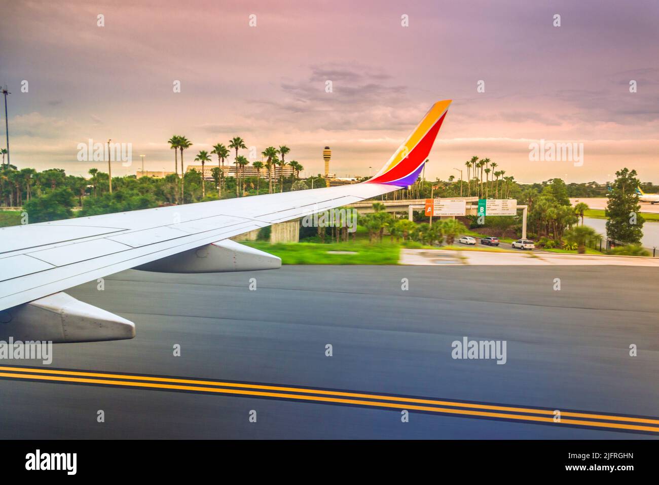 Tramonto ipnotico all'Aeroporto Internazionale di Orlando visto attraverso la finestra di una Southwest Airlines 737 dopo l'atterraggio Foto Stock