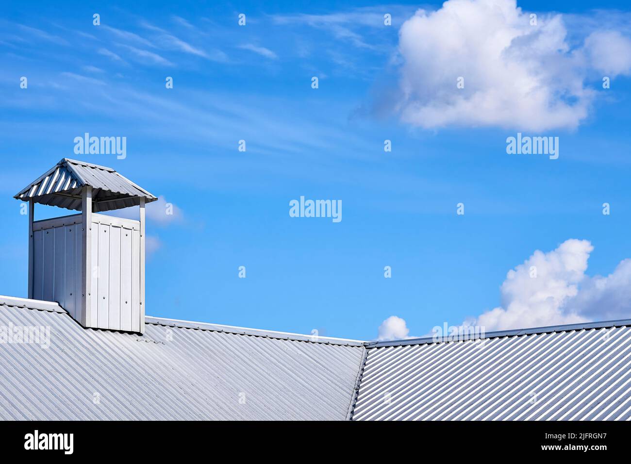 Il tetto della casa è coperto con un profilo di stagno, un camino con ventilazione Foto Stock