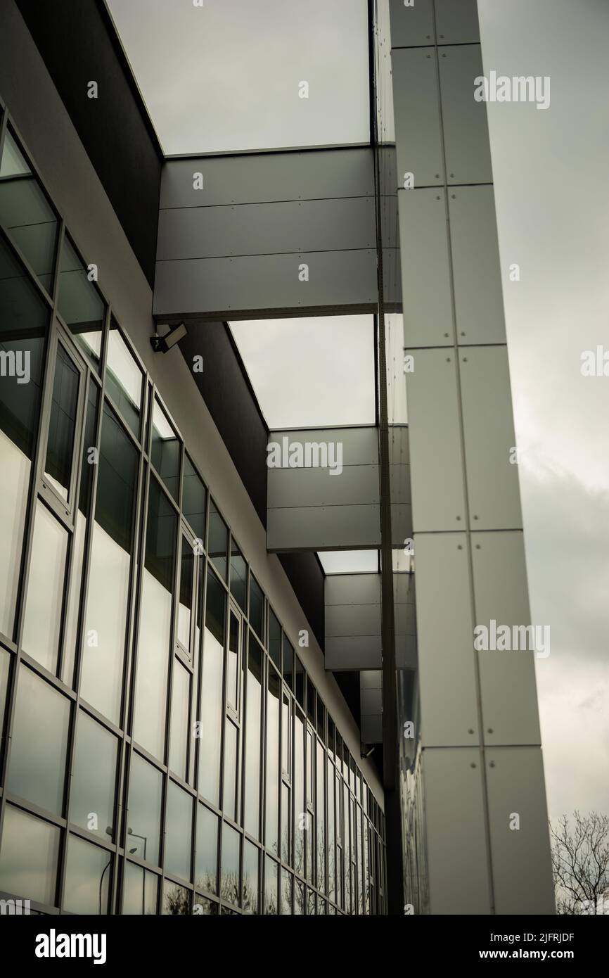 Facciata in vetro e struttura di un edificio moderno, giorno nuvoloso Foto Stock