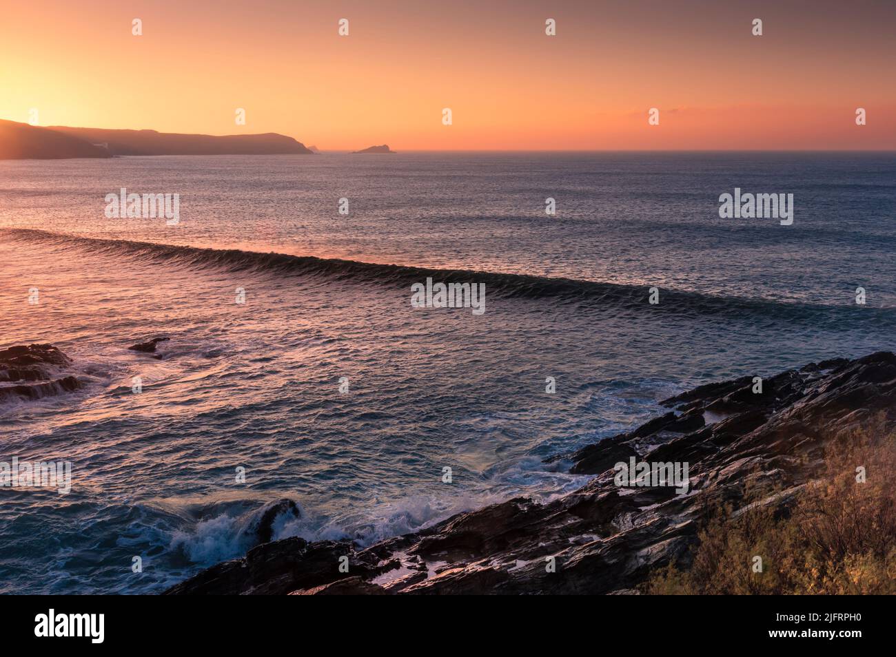 Sunset sopra le onde edificio a Fistral Bay a Newquay in Cornovaglia. Foto Stock