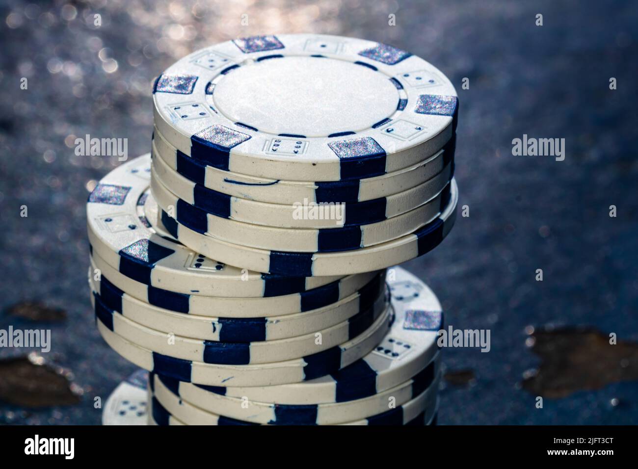 Un primo piano di una pila di chip da casinò in bianco e nero Foto Stock