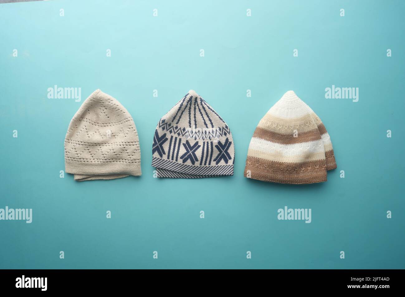 collezione di cappelli cranici per uomini musulmani su sfondo verde chiaro Foto Stock