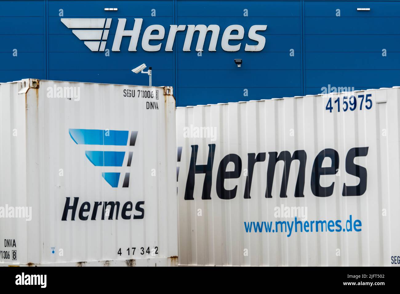 Gebäude und Container der Firma Hermes mit Schriftzug Foto Stock