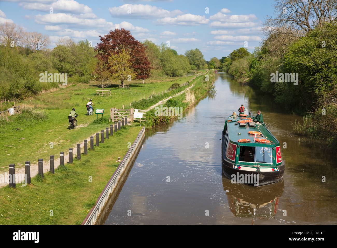 Vista lungo il canale Kennett e Avon con crociera della chiatta del canale alla luce del sole del pomeriggio, Hungerford, Berkshire, Inghilterra, Regno Unito, Europa Foto Stock