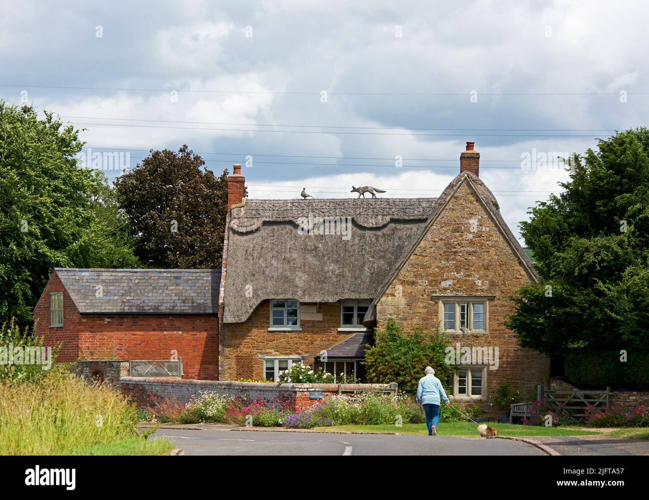 Cottage con tetto di paglia nel villaggio di Sutton Bassett, Northamptonshire, Inghilterra UK Foto Stock