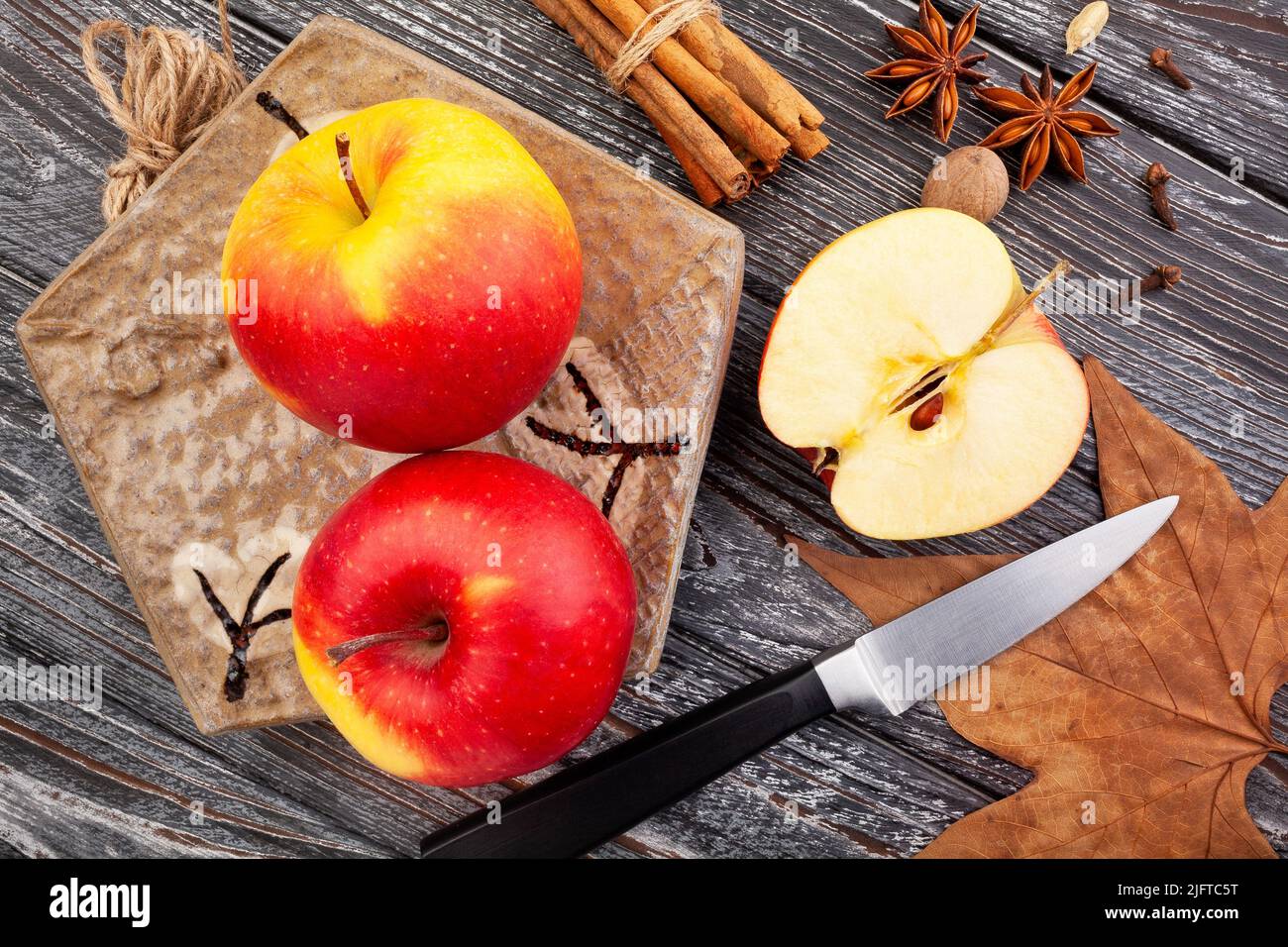 mele colorate a fette su sfondo di legno Foto Stock