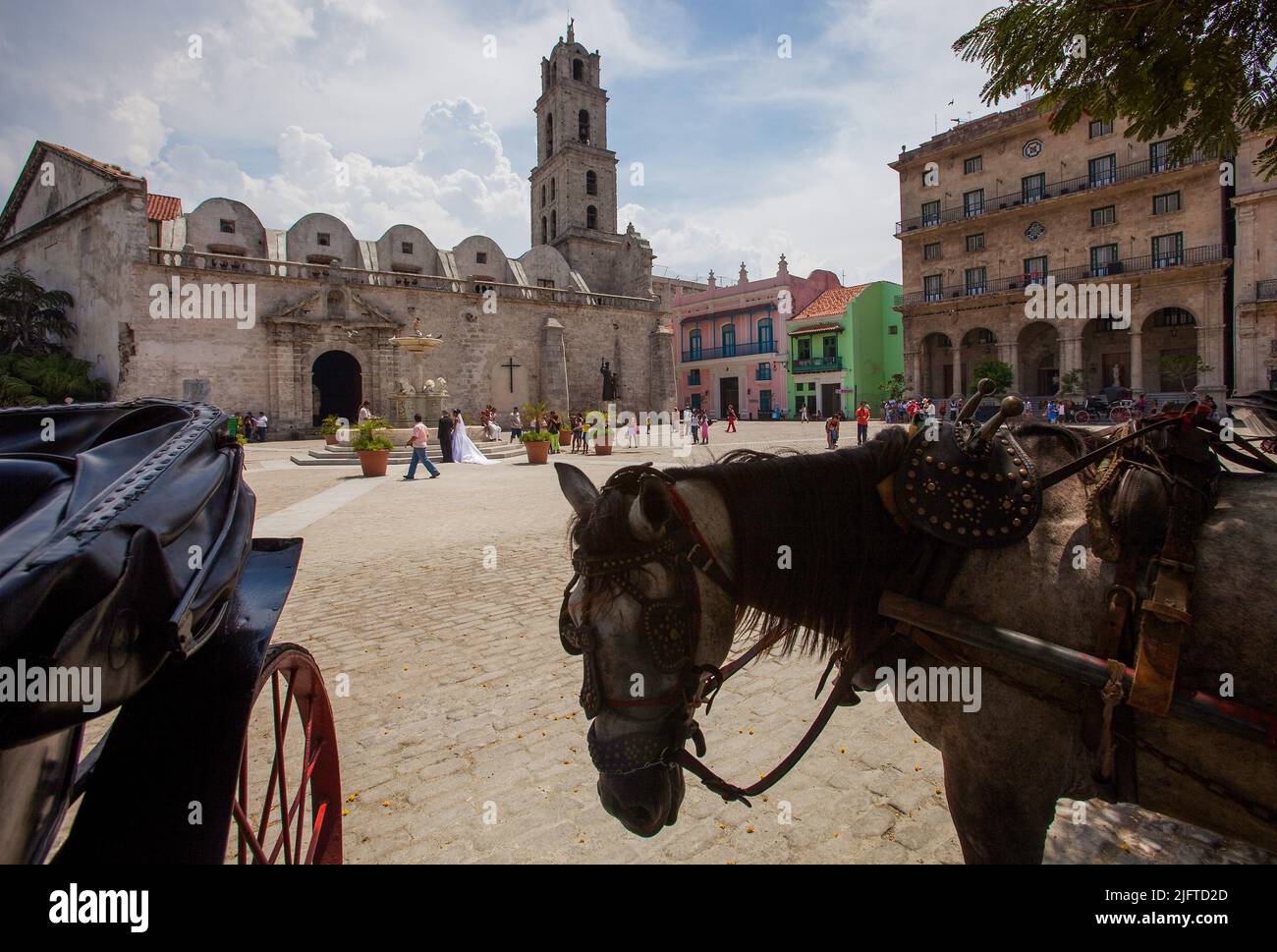 Cuba, l'Avana, Plaza de San Francisco con il convento e il Fuente de los Leones. Una coppia appena sposata sta scattando foto davanti alla fontana. Foto Stock