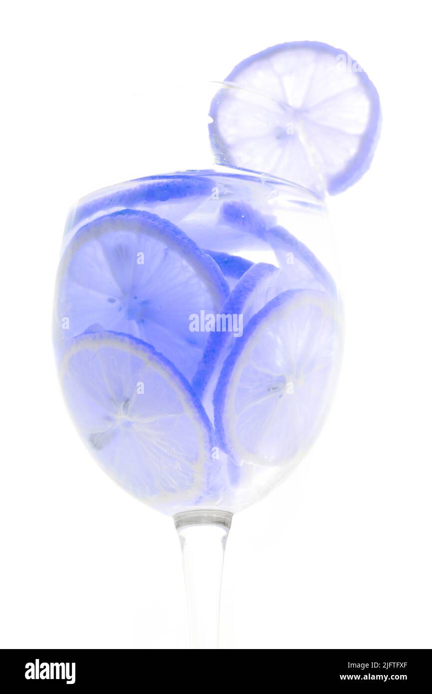 Bicchiere con cocktail a fette di lime al limone su sfondo bianco. Foto Stock