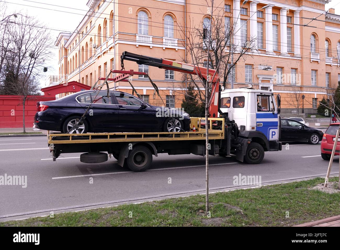 Kiev, Ucraina 13 marzo 2020: Un camion di rimorchio pulisce un'auto parcheggiata in modo improprio vicino all'Università di Taras Shevchenko a Kiev Foto Stock