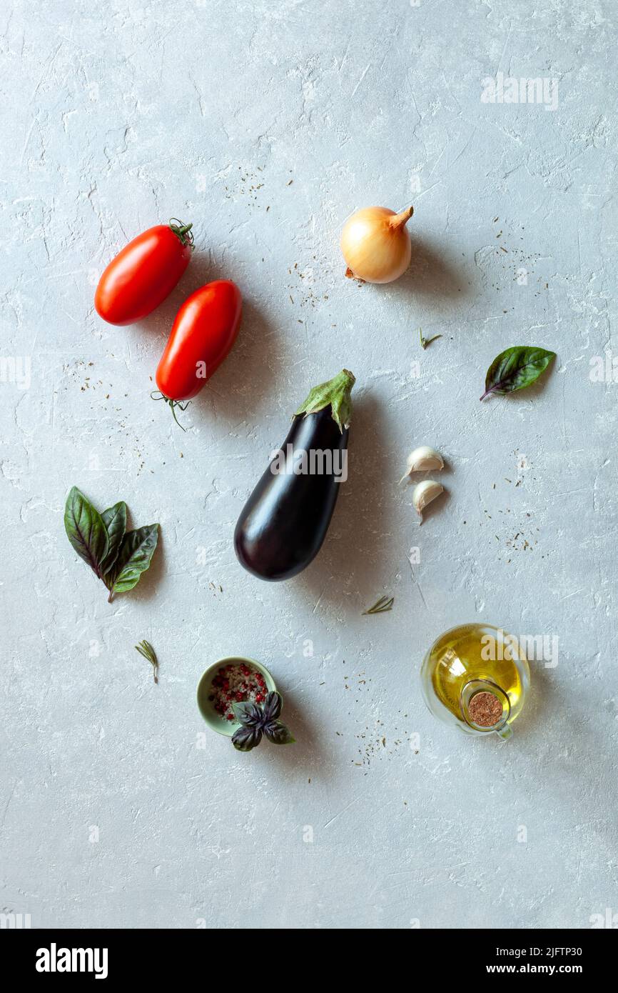 Verdure spesso utilizzate nella cucina mediterranea, vista dall'alto, sfondo grigio Foto Stock