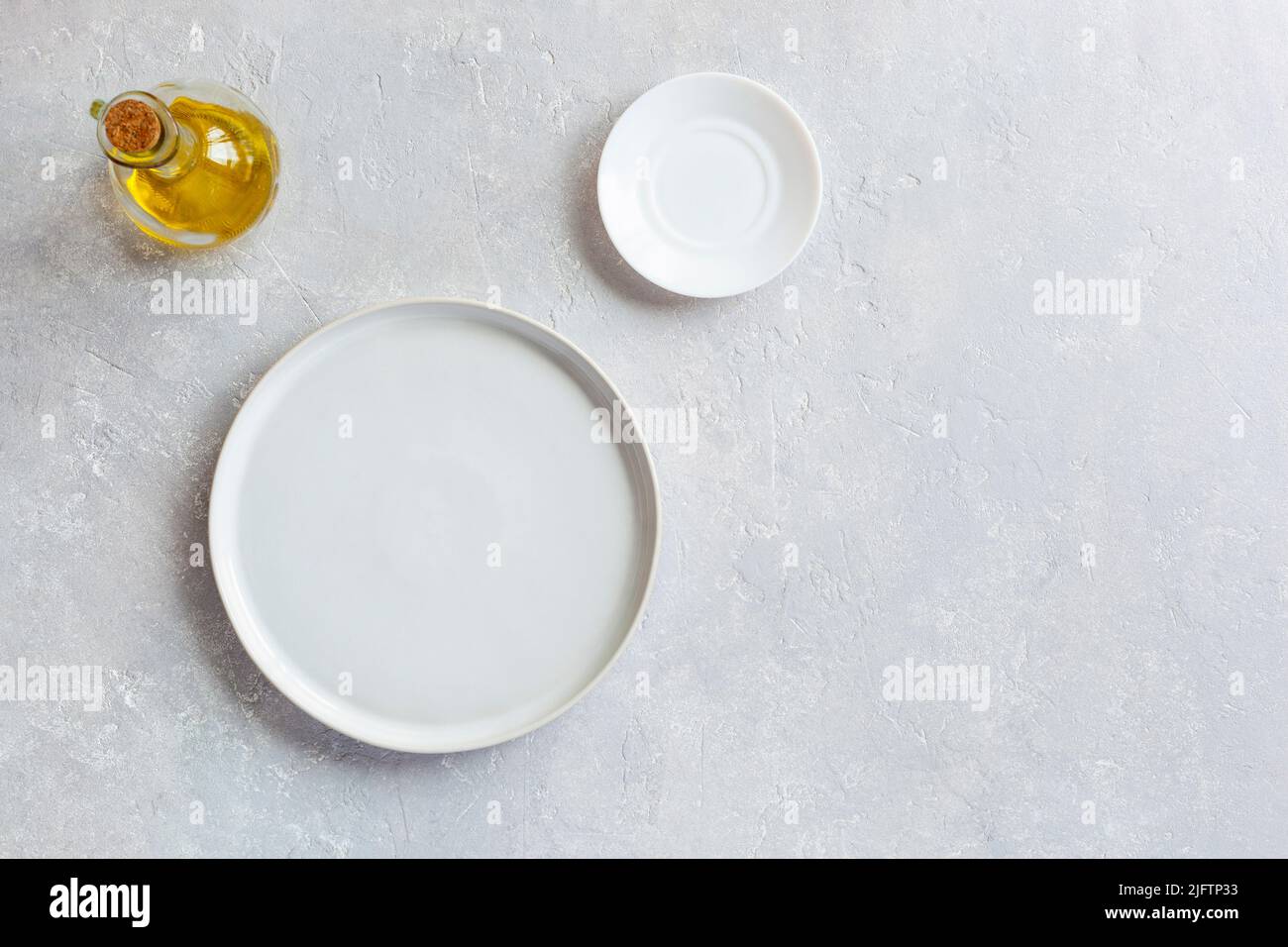 piatto da portata bianco mockup vuoto, piatto piccolo e caraffa di olio d'oliva, vista dall'alto, spazio copia Foto Stock