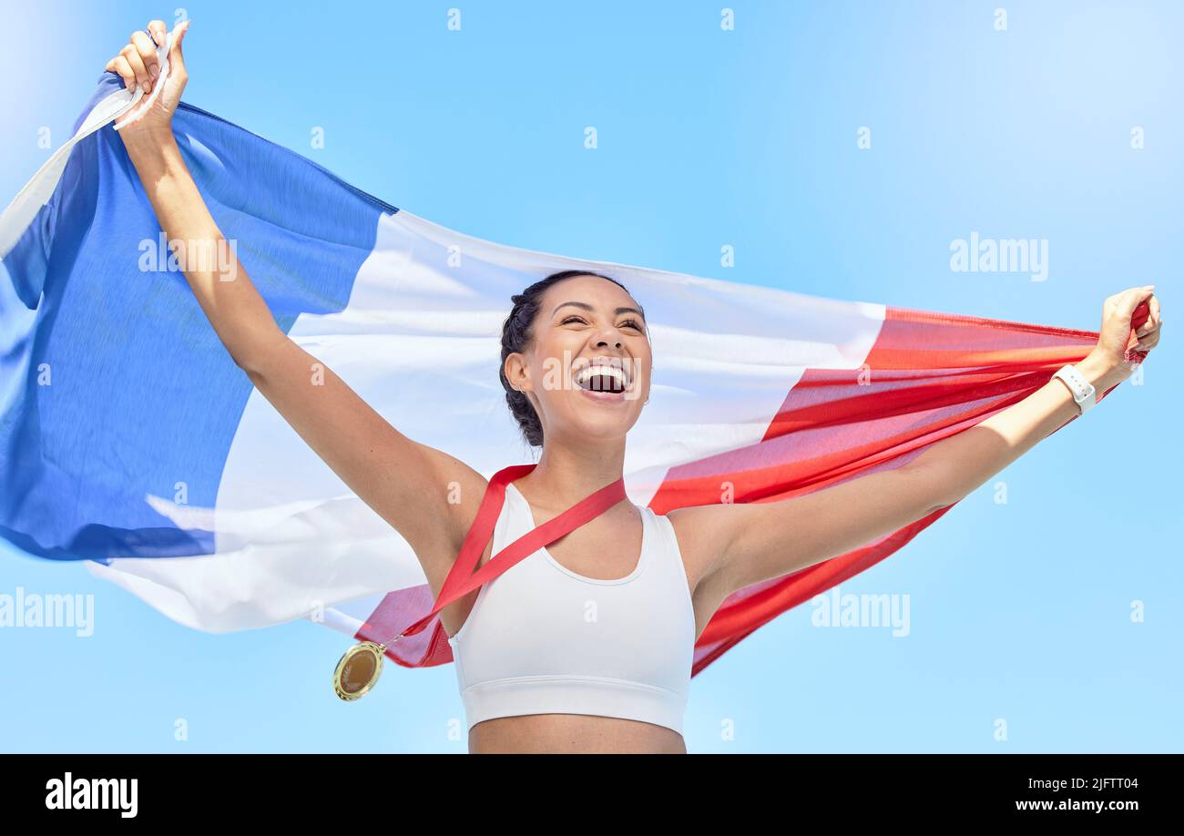 L'atleta francese festeggia la sua vittoria olimpica con la medaglia d'oro, battendo una bandiera. Sorridente fit attiva sportiva donna sensazione motivata. Festeggiamo l'orgoglio nazionale Foto Stock