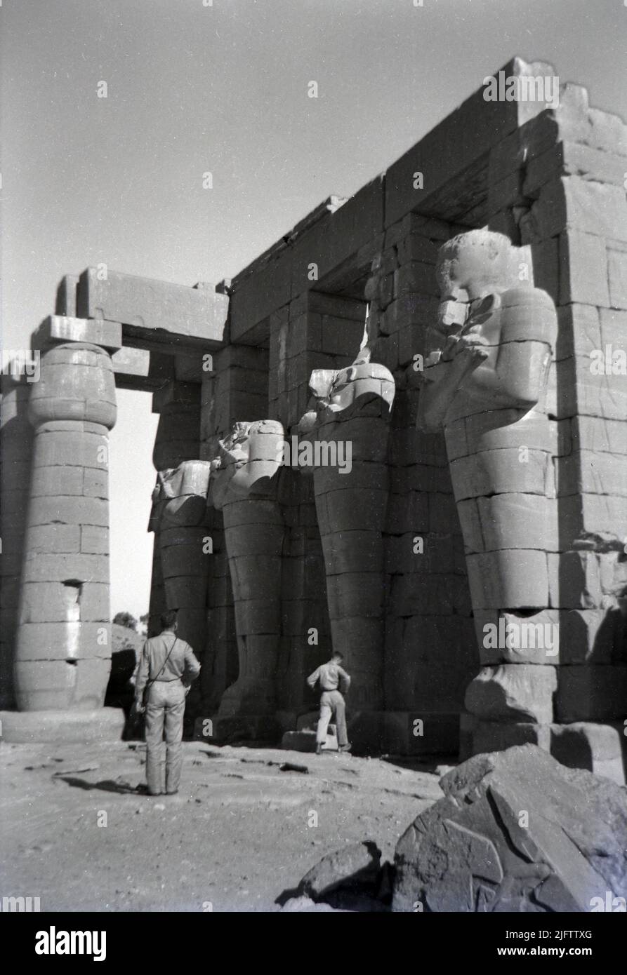 Egitto Luxor Tempio di Karnak rovine Ramesseum di Ramseses II Tebe foto d'epoca scattata alla fine del 1940s due uomini che osservano le rovine Foto Stock