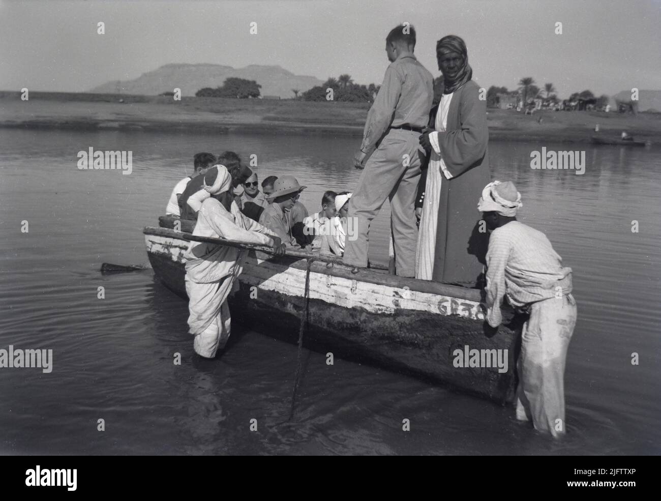 1940s uomini che vengono caricati in una barca a remi sul fiume Nilo a Luxor Egitto Foto Stock