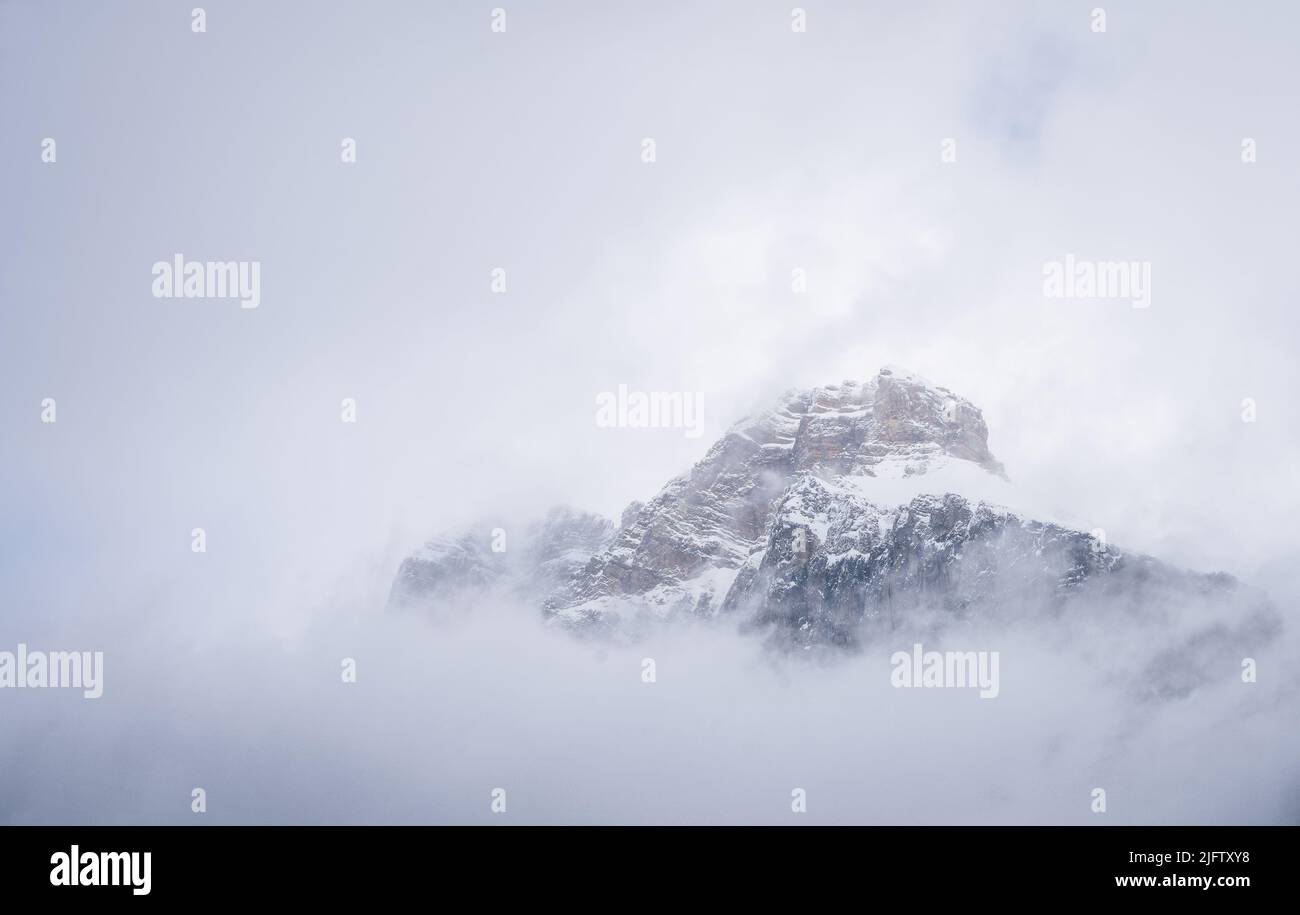 Isolato picco alpino nevoso avvolto da nuvole e nebbia, Yoho N. Park, Canada Foto Stock