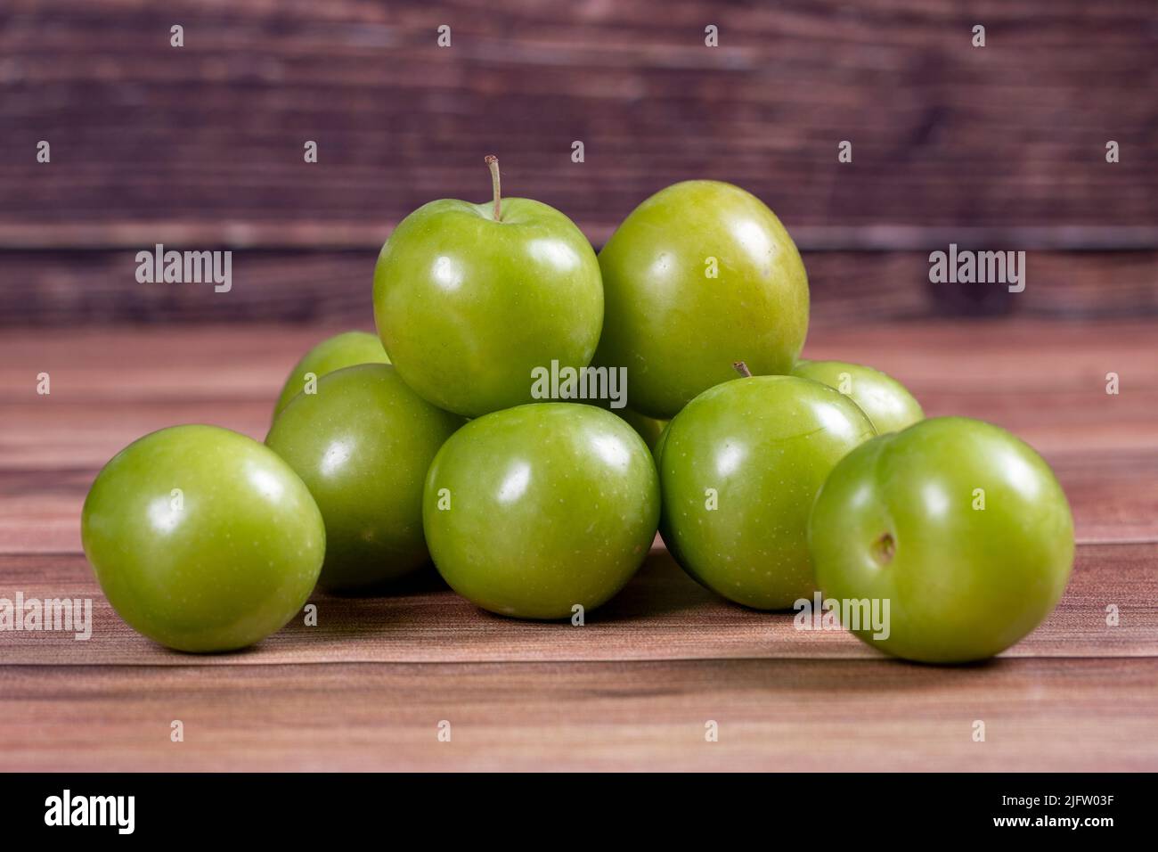 Prugna verde su sfondo di legno. Mucchio di prugne verdi. Primo piano su Foto Stock