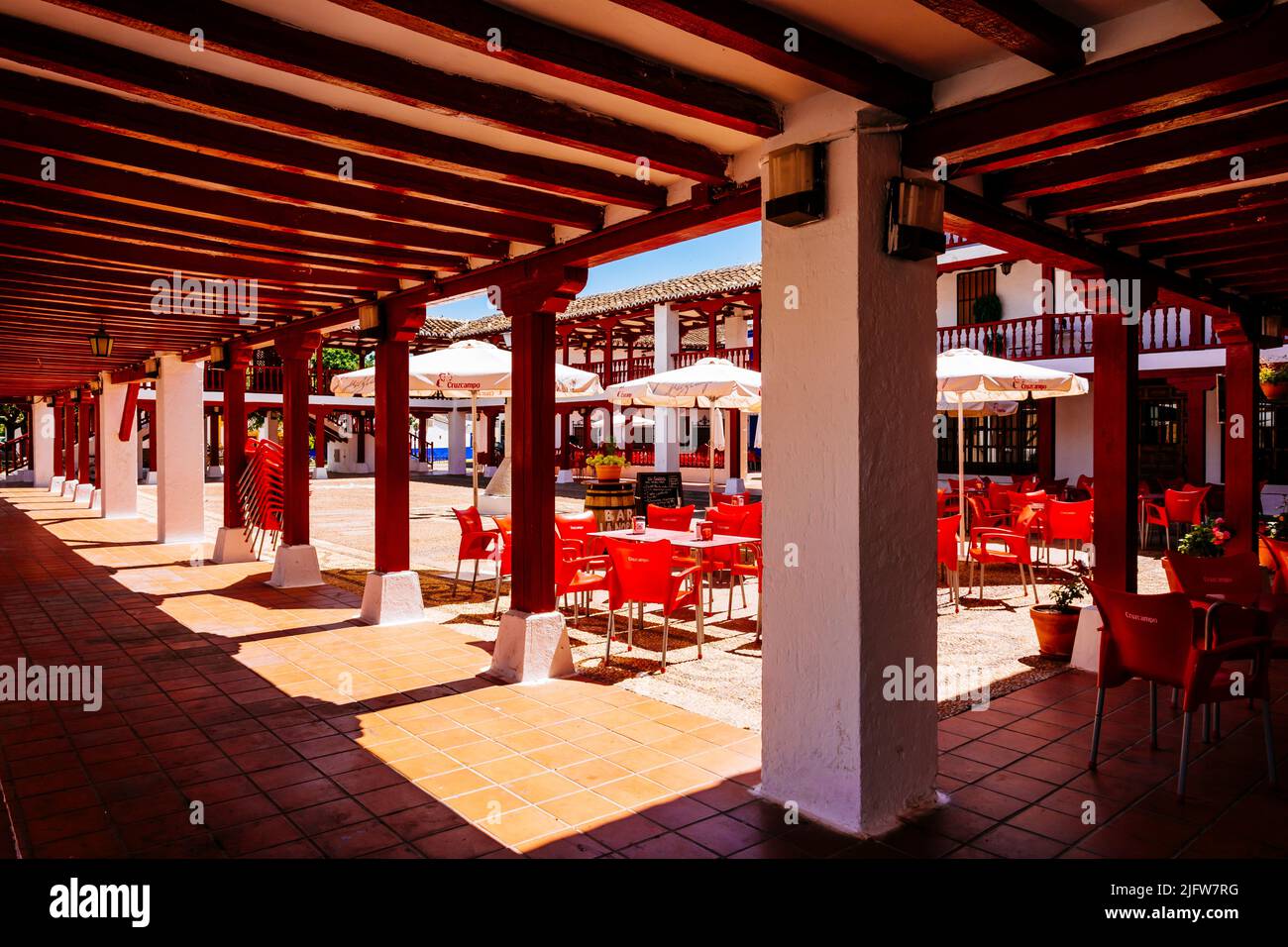 Plaza de la Constitución, Plaza Mayor, a Puerto Lápice è una piazza in stile la Mancha, con due livelli di arcate in legno dipinte di rosso. Puerto Lápice, Foto Stock