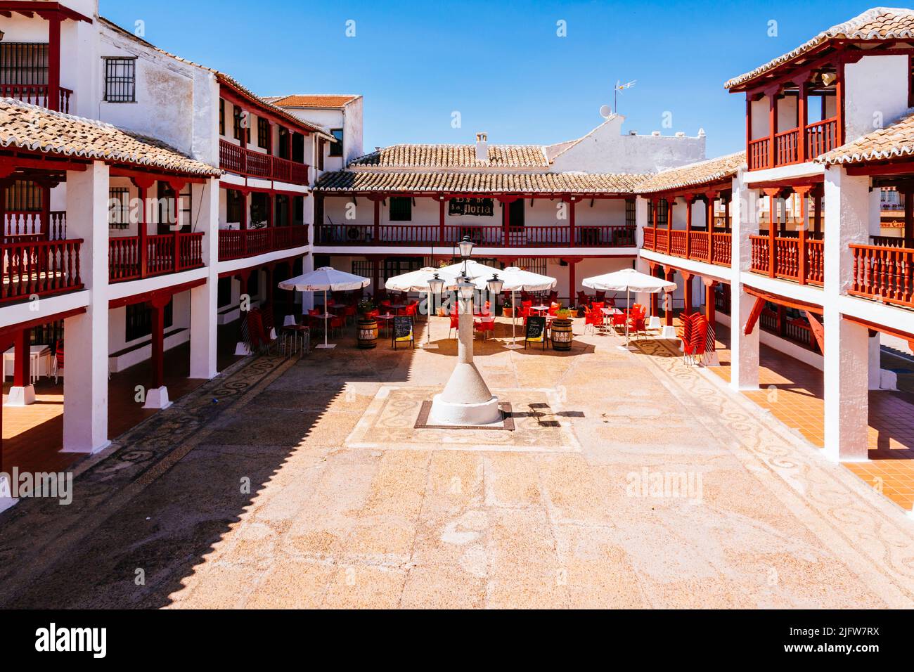 Plaza de la Constitución, Plaza Mayor, a Puerto Lápice è una piazza in stile la Mancha, con due livelli di arcate in legno dipinte di rosso. Puerto Lápice, Foto Stock
