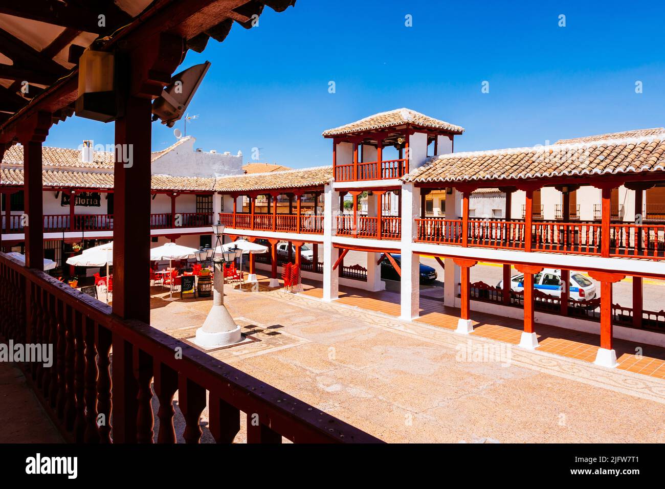 Plaza de la Constitución, Plaza Mayor, a Puerto Lápice è una piazza in stile la Mancha, con due livelli di arcate in legno dipinte di rosso. Puerto Lápice, Foto Stock