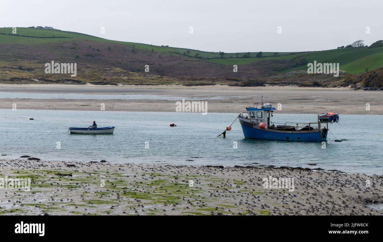 West Cork, Irlanda, 30 aprile 2022. Una barca da pesca in acque poco profonde. Un uomo in barca. Paesaggio marino. Foto Stock