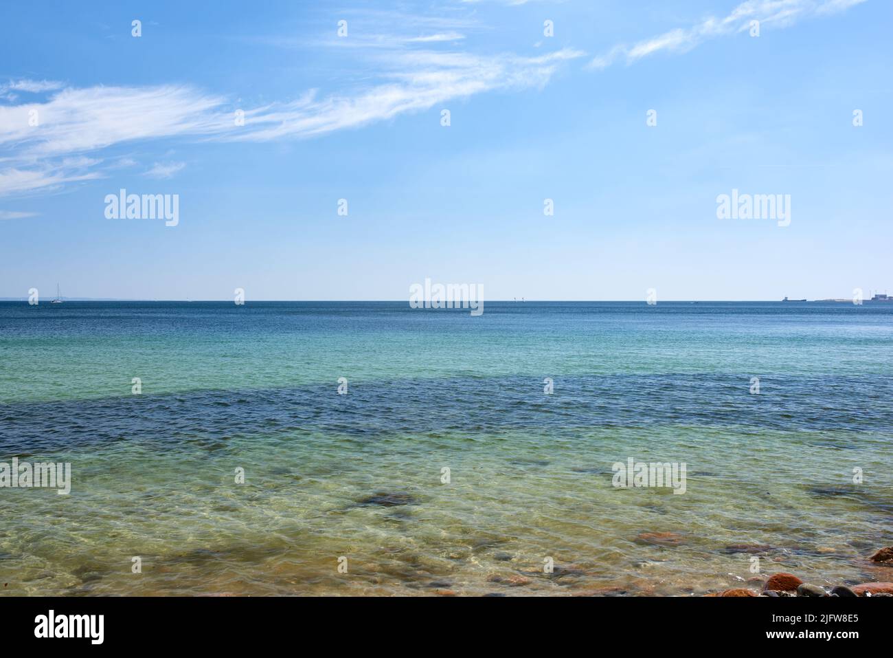 Calme spiagge di mare su un orizzonte blu e costa rocciosa. Paesaggio panoramico dell'oceano tropicale in una giornata estiva. Vista tranquilla della spiaggia serena scena Foto Stock