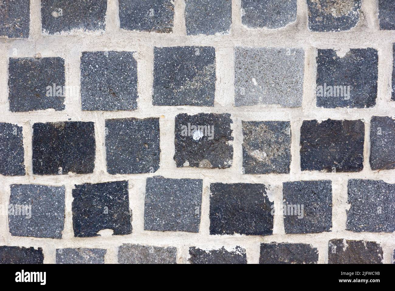 Un muro di fatto di mattoni grigi Foto Stock