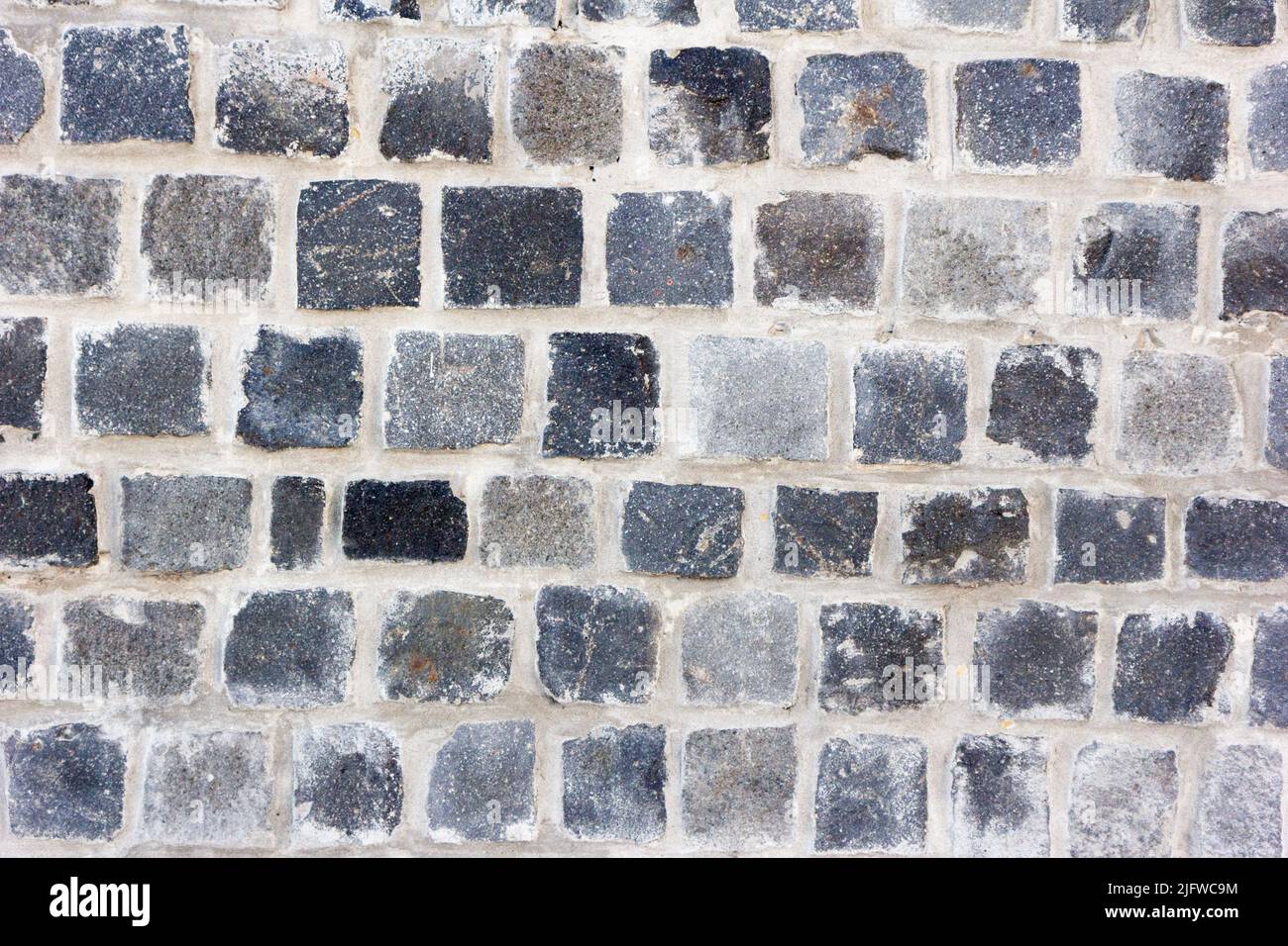 Un muro di fatto di mattoni grigi Foto Stock
