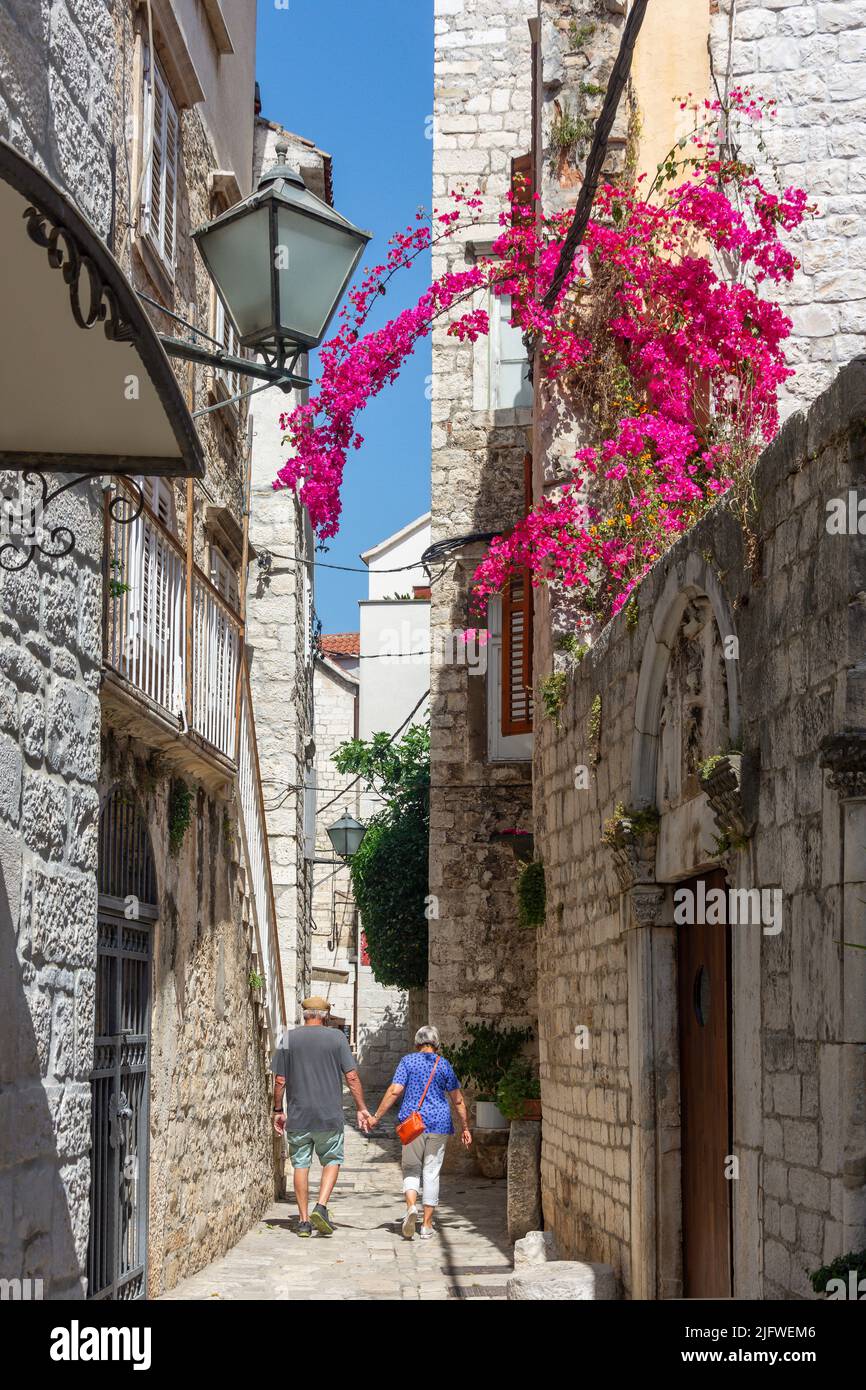 Coppia a piedi in strada, Città Vecchia, Trogir, Contea di Spalato-Dalmazia, Croazia Foto Stock