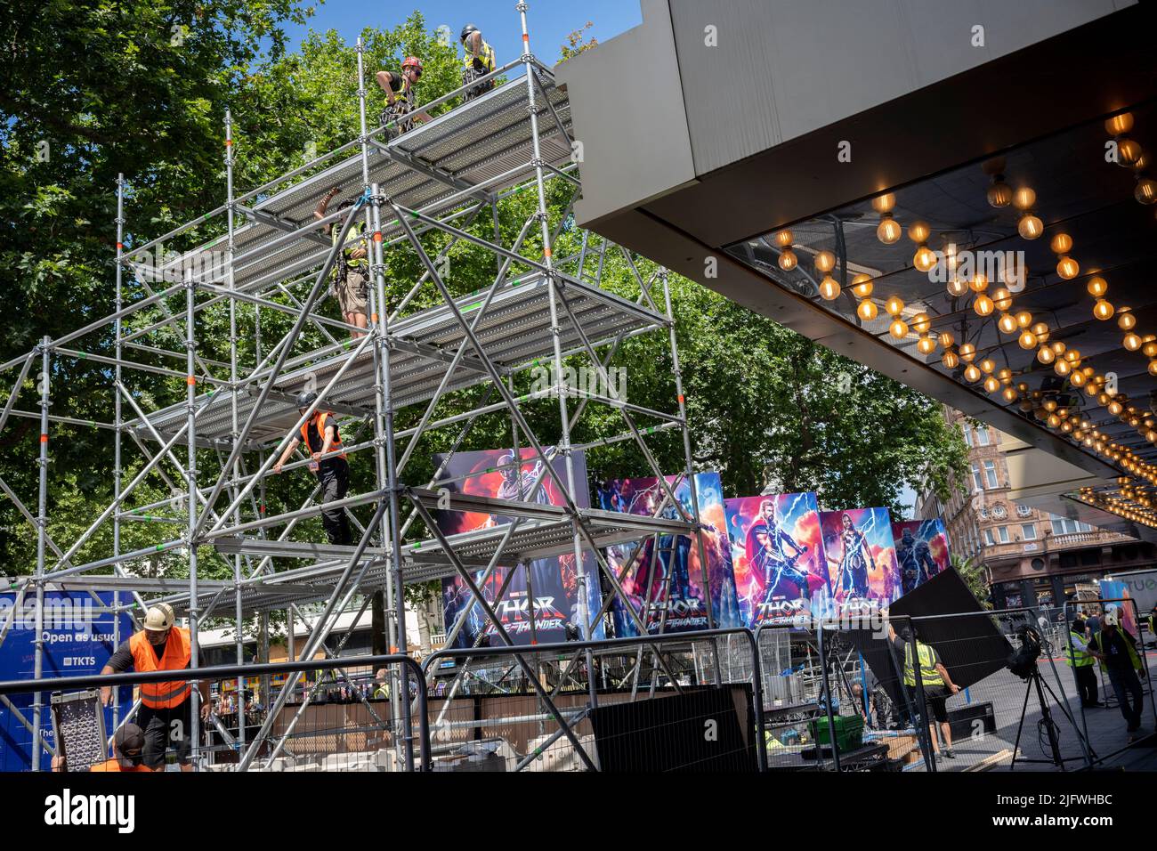 Un equipaggio di lavoro prepara l'area del tappeto rosso dove sono già in atto cartelloni pubblicitari per l'ultimo film Marvel 'Thor: Love and Thunder' il cui evento principale viene mostrato a Leicester Square più tardi stasera, il 5th luglio 2022, a Londra, Inghilterra. Foto Stock