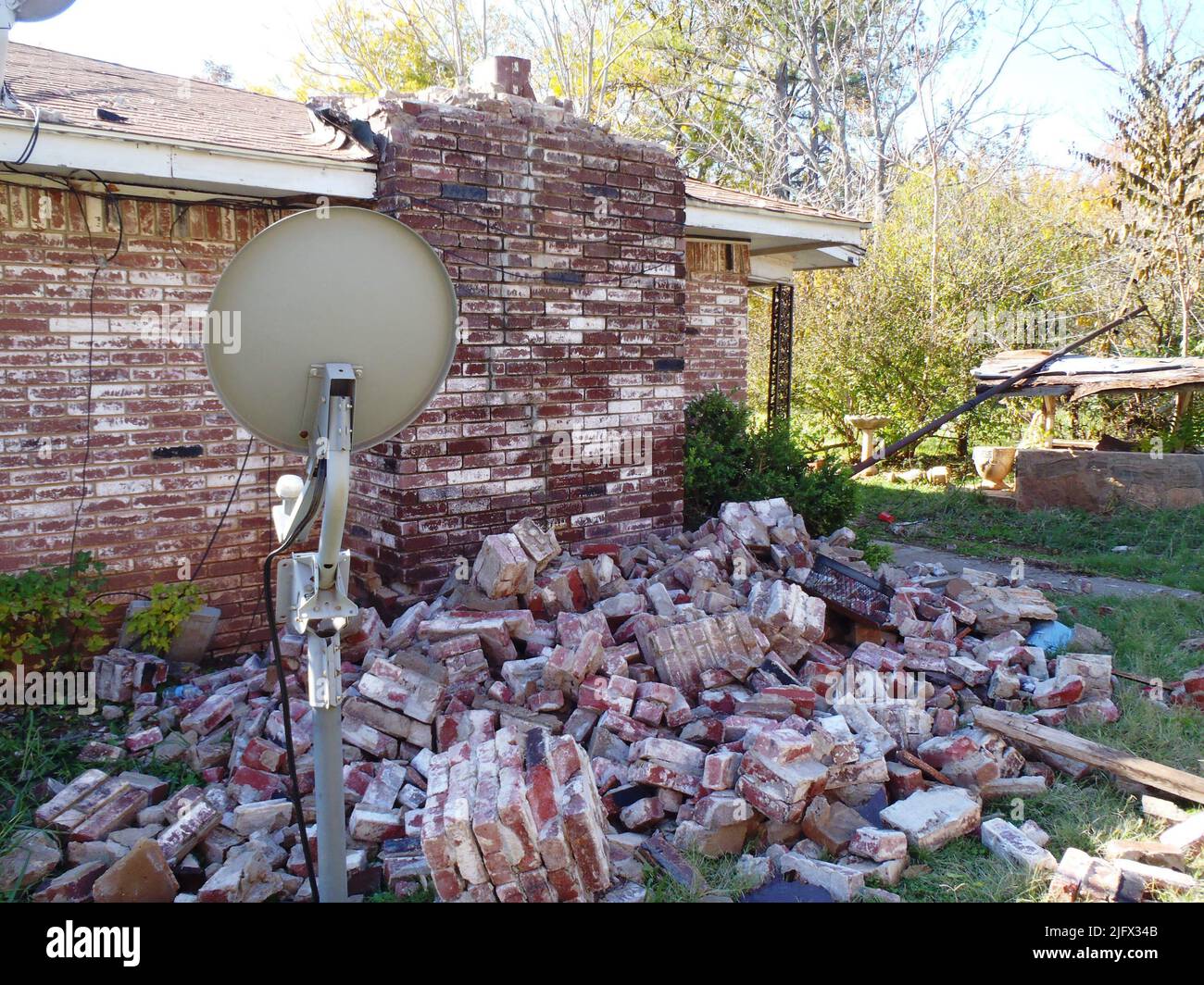 Una casa di danni nel centro dell'Oklahoma dal terremoto di magnitudo 5,6 il 6 novembre 2011. Una ricerca condotta dalla geofisica della USGS Elizabeth Cochran e dai suoi colleghi universitari suggerisce che questo terremoto è stato indotto da iniezione in pozzi di smaltimento profondi nel campo di Wilzetta North. Photo credit: Brian Sherrod, USGS. Foto Stock
