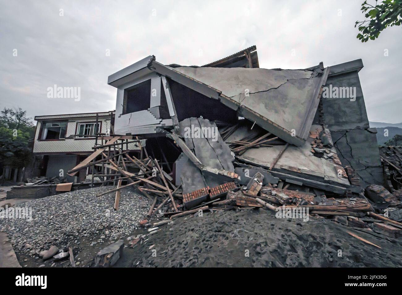 Danni ad una casa di villaggio in Sichuan, Cina dopo il terremoto di Lushan del M6,6 del 20 Apri 2013. Costruzione di strutture più sicure. In questo secolo, i terremoti maggiori negli Stati Uniti hanno danneggiato o distrutto numerosi edifici, ponti e altre strutture. Monitorando il modo in cui le strutture rispondono ai terremoti e applicando le conoscenze acquisite, scienziati e ingegneri stanno migliorando la capacità delle strutture di sopravvivere ai terremoti più gravi. Molte vite e milioni di dollari sono già stati salvati da questa ricerca in corso. Credito: USGS. Foto Stock